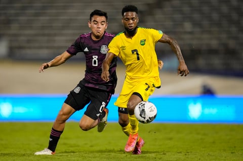 Mexico's Carlos Rodriguez chases Jamaica's Lamar Walker during a qualifying soccer match for the FIFA World Cup Qatar 2022 in Kingston, Jamaica, Thursday, Jan. 27, 2022. (AP Photo/Ramon Espinosa)