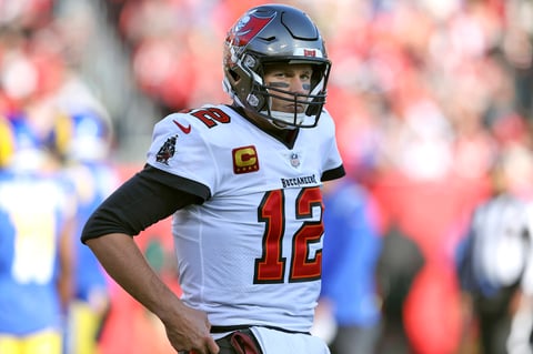 Tom Brady (12), quarterback de Buccaneers de Tampa Bay, reacciona después de ser castigado durante la primera mitad del juego de la ronda divisional de playoffs en contra de los Rams de Los Ángeles, el domingo 23 de enero de 2022, en Tampa, Florida. (AP Foto/Mark LoMoglio)