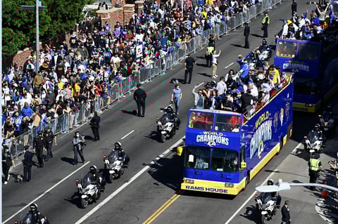 Buses carrying Los Angeles Rams players and coaches drive past fans during the team's victory parade in Los Angeles, Wednesday, Feb. 16, 2022, following their win Sunday over the Cincinnati Bengals in the NFL Super Bowl 56 football game. (AP Photo/Kyusung Gong)