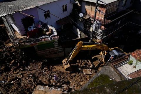 A bulldozer clears out a street in an area affected by landslides in Petropolis, Brazil, Thursday, Feb. 17, 2022. Rio de Janeiro state’s government has confirmed 94 deaths from floods and mudslides that swept away homes and cars in the city of Petropolis but It’s still unclear how many bodies remained trapped in the mud. (AP Photo/Silvia Izquierdo)