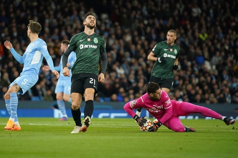 Sporting's Paulinho , center left, reacts after Manchester City's goalkeeper Ederson saved his shot during the Champions League round of 16 second leg soccer match between Manchester City and Sporting Lisbon at the City of Manchester Stadium in Manchester, England, Wednesday, March 9, 2022. (AP Photo/Dave Thompson)