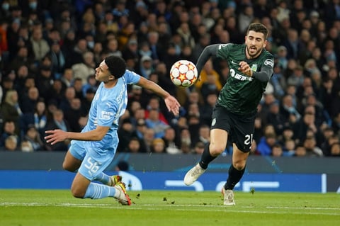 Sporting's Paulinho, right, gets past Manchester City's Conrad Jaden Egan-Riley during the Champions League round of 16 second leg soccer match between Manchester City and Sporting Lisbon at the City of Manchester Stadium in Manchester, England, Wednesday, March 9, 2022. (AP Photo/Dave Thompson)