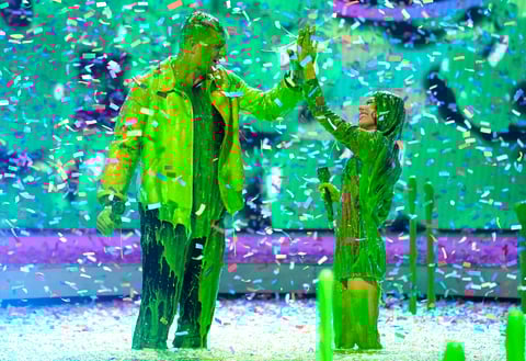 Hosts Rob Gronkowski, left, and Miranda Cosgrove get slimed at the conclusion of the Kids Choice Awards on Saturday, April 9, 2022, at the Barker Hangar in Santa Monica, Calif. (AP Photo/Chris Pizzello)
