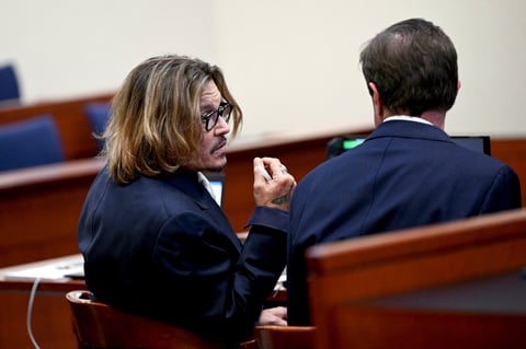 US actor Johnny Depp (L) speaks with his attorney during the $50 million Depp vs Heard deformation trial at the Fairfax County Circuit Court in Fairfax, Virginia, on April 12, 2022. (Photo by Brendan SMIALOWSKI / POOL / AFP)