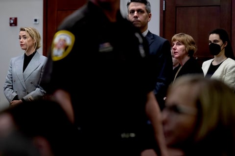 Actress Amber Heard left, listens inside the courtroom at the Fairfax County Circuit Court, April 12, 2022, in Fairfax, Va. A jury in Virginia is scheduled to hear opening statements in a defamation lawsuit filed by Johnny Depp against his ex-wife, Amber Heard. (Brendan Smialowski, Pool via AP)