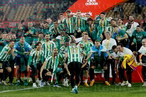 SEVILLA, 23/04/2022.- Los jugadores del Betis tras recibir el trofeo que les acredita campeones de la Copa del Rey al derrotar al Valencia en la tanda de penaltis en el encuentro que han disputado este sábado en el estadio de La Cartuja de Sevilla. EFE/Jose Manuel Vidal