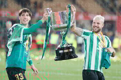 SEVILLA, 23/04/2022.- Los jugadores del Betis, Juan Miranda (i) y Aitor Ruibal, celebran la victoria del equipo bético en la final de la Copa del Rey al derrotar al Valencia en el encuentro que han disputado este sábado en el estadio de La Cartuja de Sevilla. EFE/José Manuel Vidal