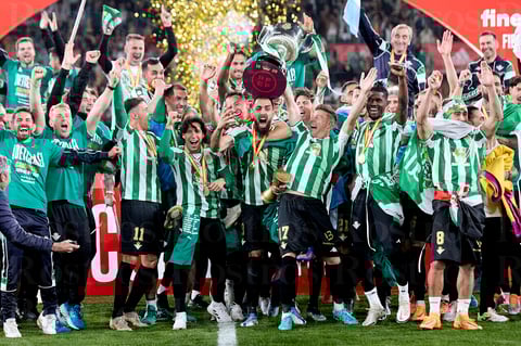 SEVILLA, 24/04/2022.- Los jugadores del Betis posan con el trofeo de Campeón de la Copa del Rey a la finalización del encuentro que han disputado hoy sábado frente al Valencia en el estadio de La Cartuja, en Sevilla. EFE / Pablo García / RFEF ***SOLO USO EDITORIAL, SOLO DISPONIBLE PARA ILUSTRAR LA NOTICIA QUE ACOMPAÑA (CRÉDITO OBLIGATORIO)***