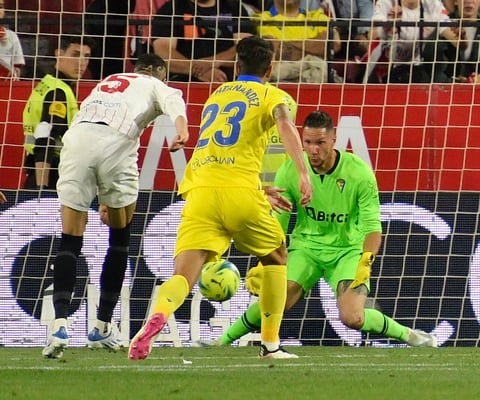 SEVILLA, 29/04/2022.- El delantero del Sevilla Youssef En-Nesyri (i) chuta ante el portero Jeremías Ledesma, del Cádiz, durante el partido de Liga en Primera División disputado este viernes en el estadio Ramón Sánchez-Pizjúan, en Sevilla. EFE/Raúl Caro