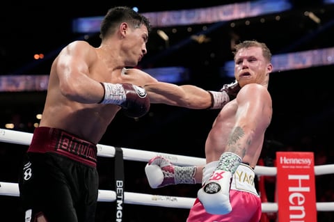 Dmitry Bivol, left, of Kyrgyzstan, throws a punch against Canelo Alvarez, of Mexico, during a light heavyweight title fight, Saturday, May 7, 2022, in Las Vegas. (AP Photo/John Locher)