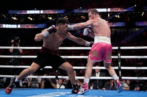 Canelo Alvarez, right, of Mexico, and Dmitry Bivol, of Kyrgyzstan, fight during a light heavyweight title match, Saturday, May 7, 2022, in Las Vegas. (AP Photo/John Locher)