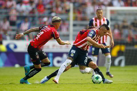 AME9620. GUADALAJARA (MÉXICO), 15/05/2022.- Luis Reyes (i) y Jeremy Márquez (atrás) de Atlas disputan hoy el balón con Roberto Alvarado de Chivas, durante la vuelta de los cuartos de final del torneo Clausura 2022, en el Estadio Jalisco en Guadalajara (México). EFE/ Francisco Guasco