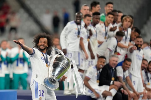 Real Madrid's Marcelo, left, gestures as holds the winning trophy end of the Champions League final soccer match between Liverpool and Real Madrid at the Stade de France in Saint Denis near Paris, Saturday, May 28, 2022. Real Madrid won 1-0. (AP Photo/Kirsty Wigglesworth)