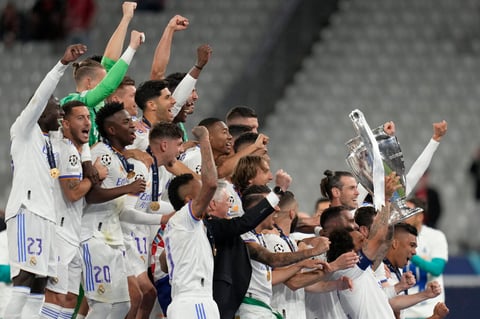 Real Madrid players celebrate with the trophy winning the Champions League final soccer match between Liverpool and Real Madrid at the Stade de France in Saint Denis near Paris, Saturday, May 28, 2022. Real Madrid won 1-0. (AP Photo/Kirsty Wigglesworth)