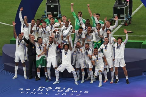 Real Madrid players celebrate with the trophy after winning the Champions League final soccer match between Liverpool and Real Madrid at the Stade de France in Saint Denis near Paris, Saturday, May 28, 2022. (AP Photo/Tony Hicks)