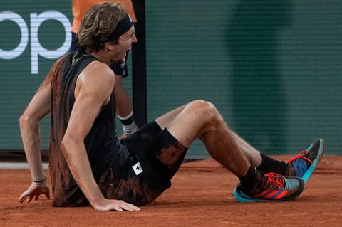 Germany's Alexander Zverev grimaces in pain after falling as he plays Spain's Rafael Nadal, during their semifinal match of the French Open tennis tournament at the Roland Garros stadium Friday, June 3, 2022 in Paris. Zverev withdrew from the match. (AP Photo/Michel Euler)