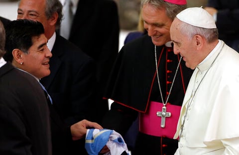 ARCHIVO - La leyenda del fútbol argentino Diego Maradona, a la izquierda, saluda al papa Francisco en el aula Pablo VI del Vaticano, el lunes 1 de septiembre de 2014. (AP Foto/Gregorio Borgia, archivo)