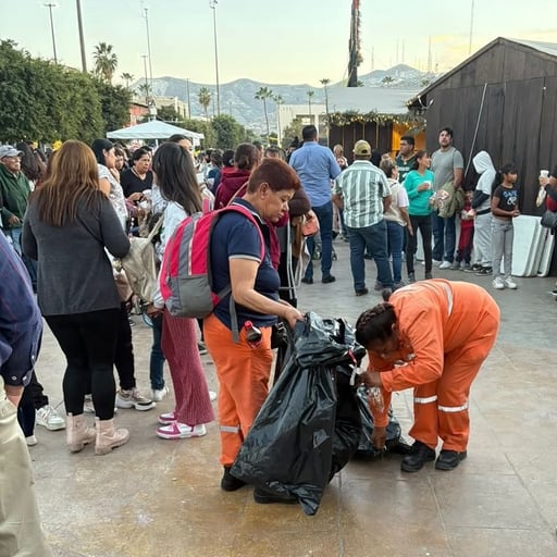 Personal de la Ola recogiendo basura en la Plaza Mayor tras la repartición de la Mega Rosca. (CORTESÍA)