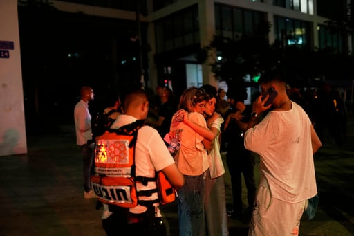 Varias personas aguardan y se apoyan mutuamente junto a un edificio alcanzado por un misil disparado desde Irán, el viernes 13 de junio de 2025, en Tel Aviv, Israel / AP


