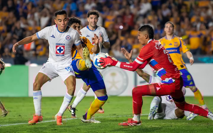 Nico Ibañez (c) delantero de los Tigres UANL, disputa el balón con Charly Rodríguez (i) y Kevin Mier (d) portero de Cruz Azul, en el partido semifinal de la ida de la Concacaf Champions Cup, jugado en el estadio Universitario de San Nicolás de los Garza, Nuevo León.
