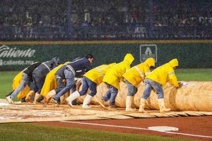 El staff de mantenimiento en el Estadio Alberto Romo Chávez colocó rápidamente la lona del infield, pero era demasiada lluvia.
