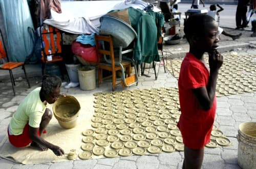 Una mujer hace galletas de lodo en el poblado del Sol, un suburbio de Puerto Príncipe. AP
