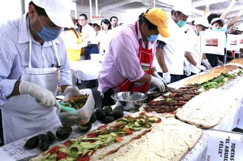 Al son de la batucada, en la VII Feria de la Torta de la delegación Venustiano Carranza se rompió el récord al elaborar en seis minutos la torta más grande del mundo, de 48 metros y más de 500 kilogramos de peso. (El Universal)