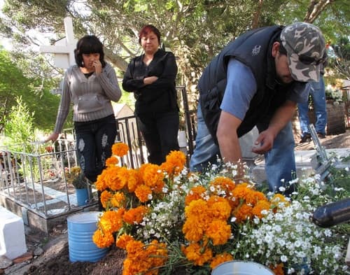 Decoran tumbas. El gasto por unas flores, por un festejo o por unas veladoras no les importa a los familiares de los difuntos.