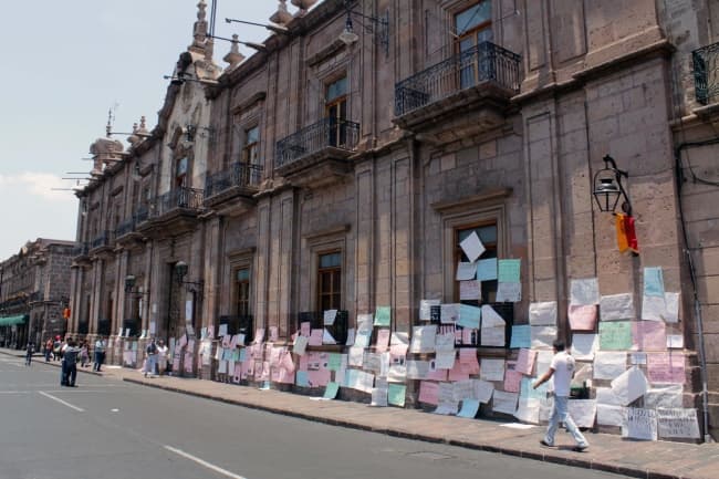 Estudiantes, familiares y organizaciones sociales forraron la fachada de Palacio de Gobierno en protesta por supuestas desapariciones y abusos policiales. EL UNIVERSAL