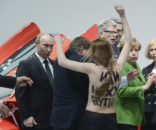 Las mujeres fueron inmediatamente detenidas por los guardaespaldas de Merkel y Putin cuando estos acababan de visitar el recinto del fabricante germano de automóviles Volkswagen. (EFE)