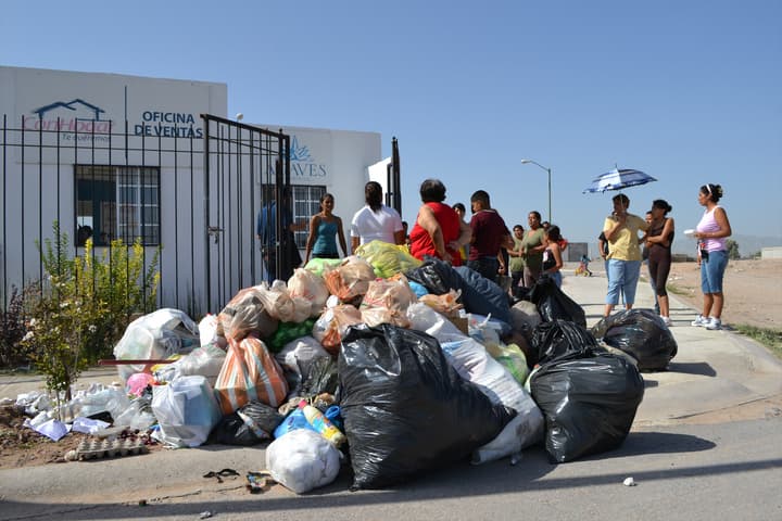 Se quejan. Dejaron la basura que no se ha recogido frente a una casa muestra.