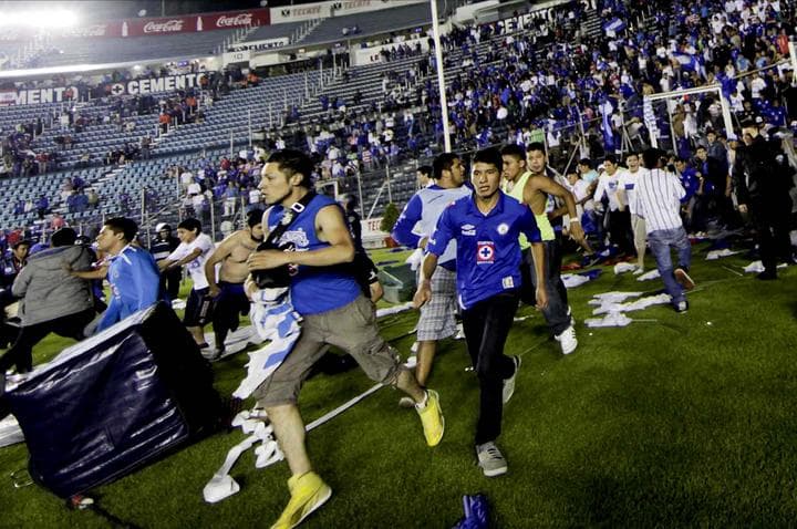 Integrantes de la barra “Sangre Azul” rompieron la seguridad e ingresaron corriendo a la cancha dirigiéndose primero al túnel donde el equipo de Cruz Azul entraba a vestidores. (El Universal)
