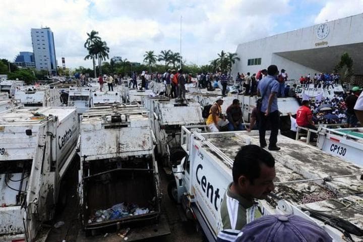 Trabajadores de limpia marcharon en Villahermosa y concluyeron su protesta por mejores sueldos llevando camiones al Palacio Municipal.