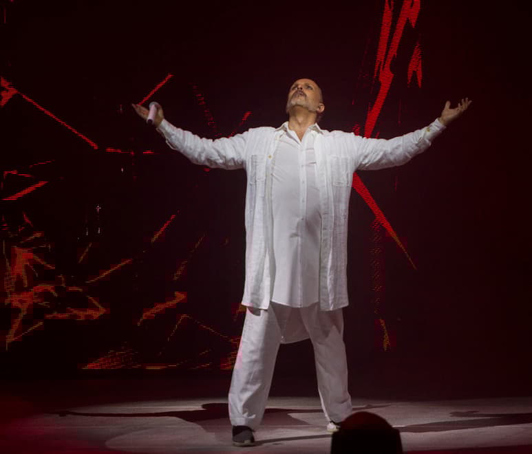 Miguel Bosé hizo su aparición en escena, vestido completamente de blanco, con ropa holgada y su cabello recogido en una coleta, pero entró solo y en silencio. (Notimex)