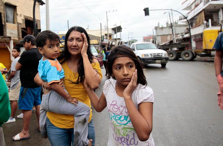 Una mujer junto a dos niños, habitantes de Pedernales, afectado por el terremoto de 7,8 grados en la escala de Richter registrado el sábado en la costa norte de Ecuador. (EFE)