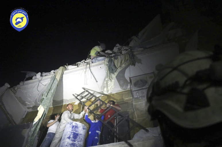 Doloroso. Rescatistas y ‘cascos blancos’ tratan de llegar al cuerpo de un joven que quedó expuesto luego de que una bomba destruyera su hogar en el vecindario de Qaterji, en Alepo.