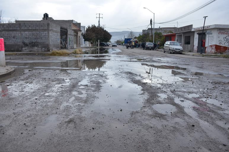 Deterioro. En calzada Hacienda del Torreón y Torreón de la Alianza, de Rincón La Merced, es común encontrar baches que se esconden tras las aguas del drenaje. (EL SIGLO DE TORREÓN)
