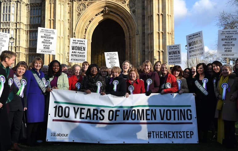 Mujeres del partido Laborista sostienen pancartas que conmemoran los 100 años desde que las mujeres británicas tienen derecho a votar, en las inmediaciones del Parlamento británico. (EFE)