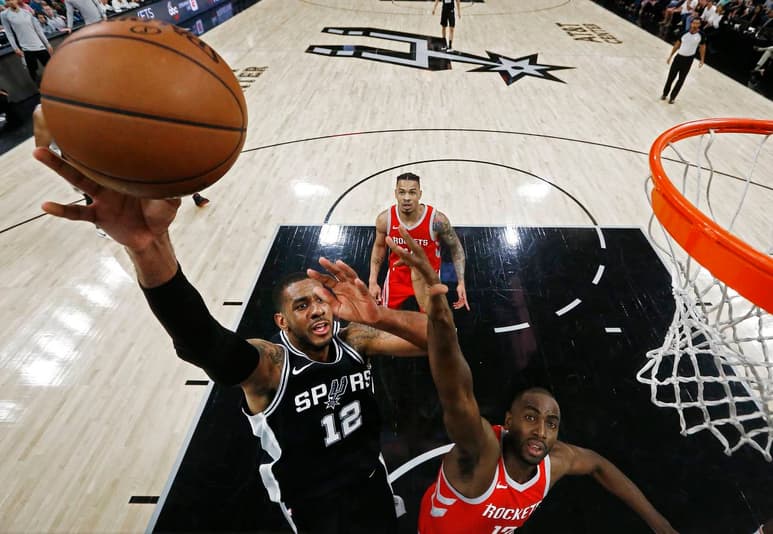 LaMarcus Aldridge, de los Spurs de San Antonio, intenta anotar frente a Luc Mhah, de los Rockets de Houston. (EFE)