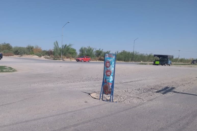 Improvisan. Propietarios de un negocio colocaron un letrero de publicidad para hacer las veces de un señalamiento vial. (ROBERTO ITURRIAGA)