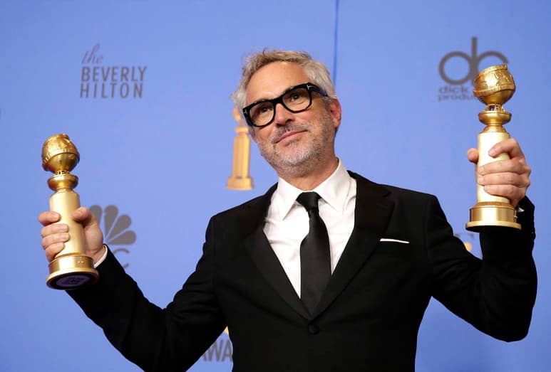 Ganador. Alfonso Cuarón con sus dos Globos de Oro, por Mejor Película Extranjera y Mejor Director. (EFE)