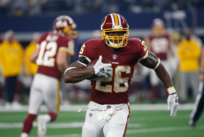 El corredor de los Redskins Adrian Peterson lleva el balón en la segunda mitad del juego ante los Cowboys de Dallas en Arlington, Texas, en 2018.