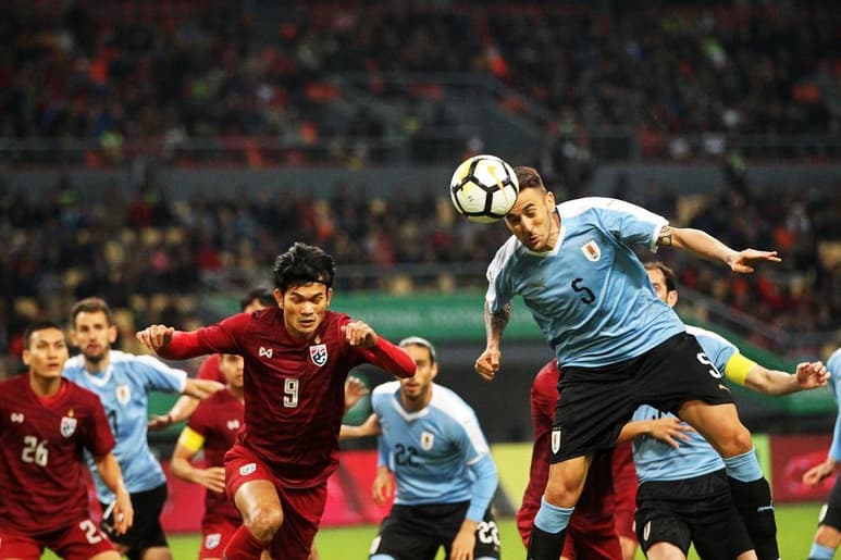Matías Vecino (d), de la selección uruguaya, disputa un balón contra el delantero de Tailandia Adisak Kraisorn.