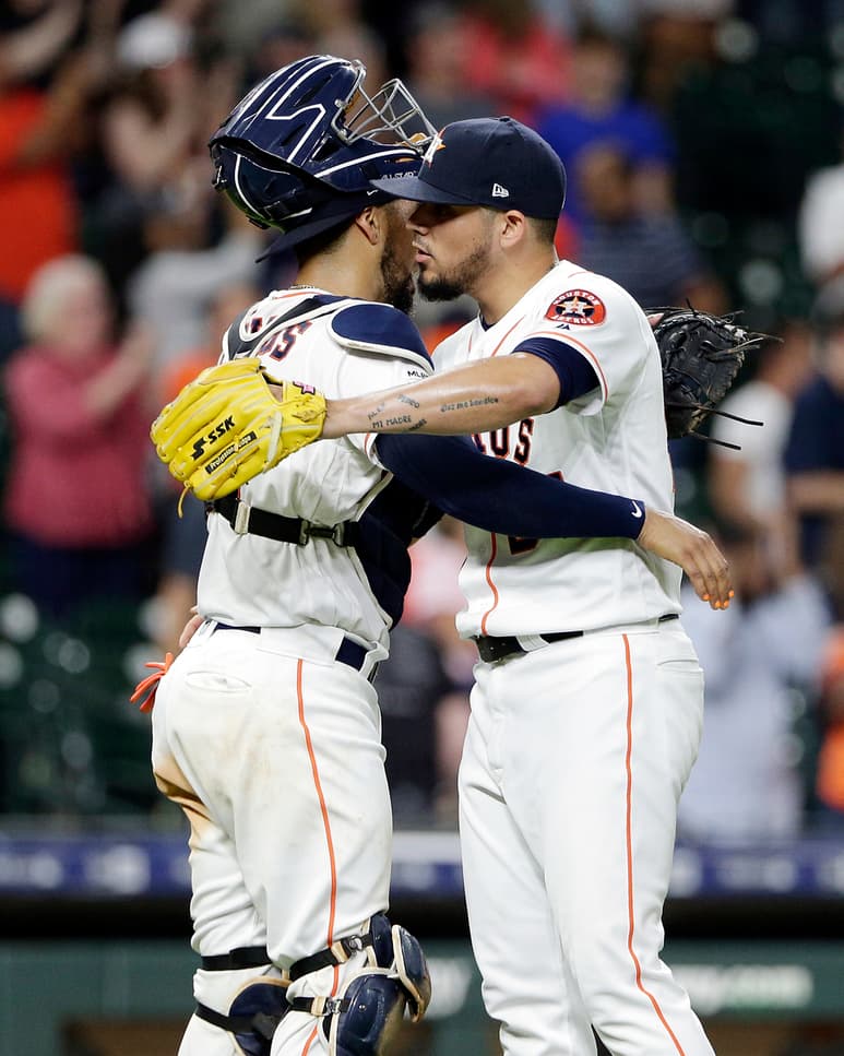 Roberto Osuna (d) festeja con Robinson Chirinos tras la victoria de los Astros 6-4 sobre Reales de Kansas. (AP)