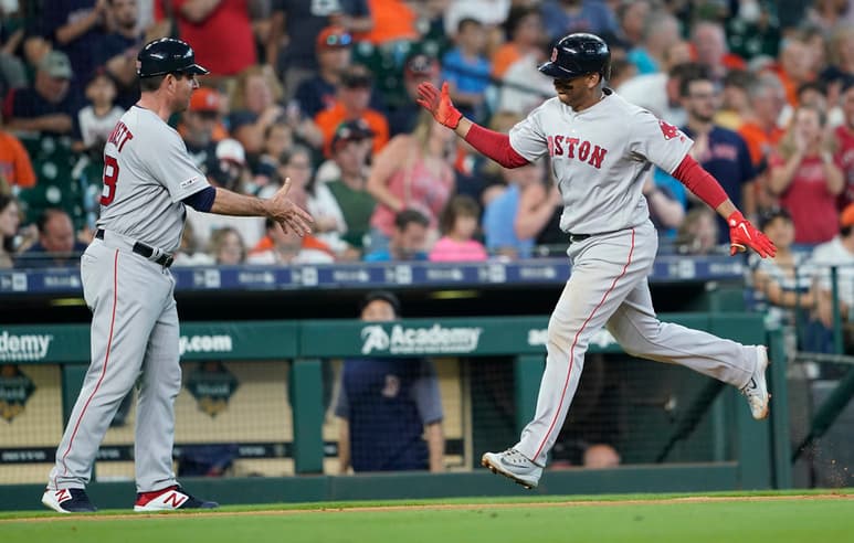 Rafael Devers (d) celebra con el coach de tercera base, Andy Barkett, tras conectar un cuadrangular en el juego de ayer. (AP)