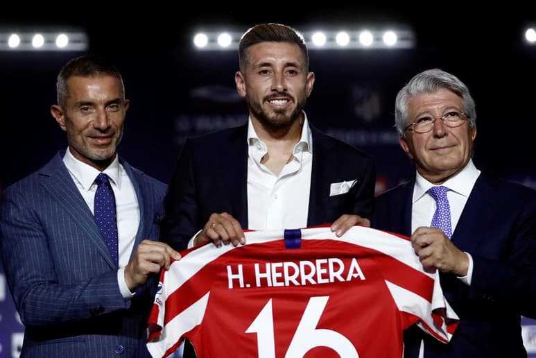 Junto al presidente del club Enrique Cerezo (d) y el director deportivo Andrea Berta (i), 'HH' luce la playera de los colchoneros.