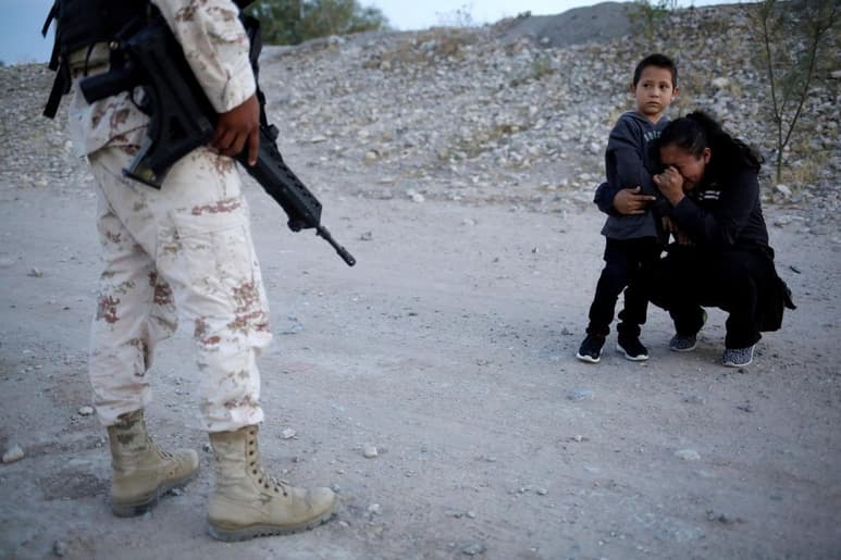 Una fotografía tomada a una mujer migrante que abraza a su hijo frente a un elemento de la Guardia Nacional se ha vuelto viral en redes sociales. (TWITTER/@Axios)