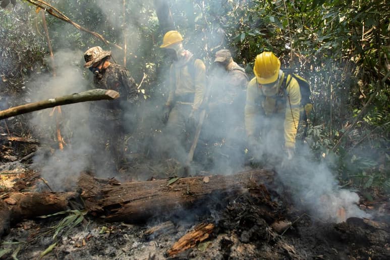 desde el inicio de la mañana los equipos de combate al fuego realizan trabajos en suelo con unas gigantescas mangueras, en tanto que desde el cielo aeronaves de las Fuerzas Armadas auxilian en el control de las llamas. (EFE)
