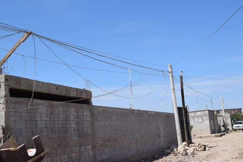 En la colonia se observan unos postes de concreto, pero no cuentan con el tendido eléctrico y las familias siguen 'colgadas'. (EL SIGLO DE TORREÓN/MARY VÁZQQUEZ)
