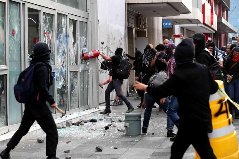 20 jóvenes que vestían de negro y algunos encapuchados, comenzaron a golpear a los uniformados. (EL UNIVERSAL)